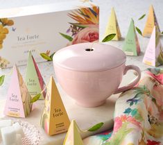 a pink tea cup surrounded by small pyramids