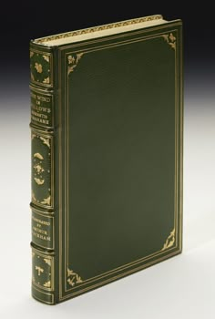 a green book with gold trimming on the cover