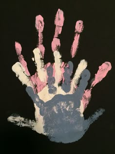 a hand print with pink and blue paint on it, in front of a black background