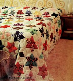 a bed with a quilt on it and a basket in the corner next to it