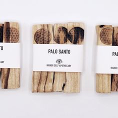 four pieces of wood with labels on them that say palo sano and honey self apothecary