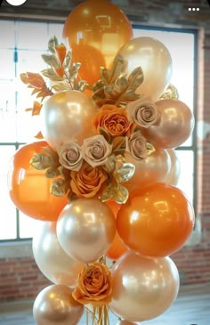 an arrangement of orange and white balloons in a vase with roses on it, along with other decorations