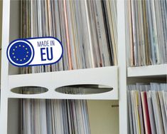 the made in eu sticker is on top of a shelf full of record records