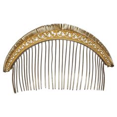 This important French ornamental hair comb was hadcrafted in 1810 ca. The beautiful handcarved head ornament has been handcarved out of brass and then fire guilt to acchieve this extraordinary gilding the french call ormolou. We see a wide freeze of delicately carved flowers and leaves decreasing in size to the sides of the comb. To embellish the carving, a spirale crerated out of a never ending grooved wire has been soldered on top of it. The silver comb carries a French hallmark. Empire Hair, Antique Hair Combs, French Empire, Objet D'art, Hair Comb, Comb, Hand Carved, Brass, Carving