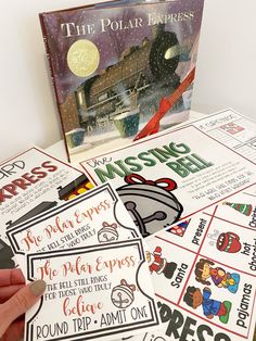 a hand holding a mouse next to a book about the polar express and other activities