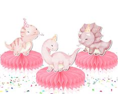 three pink paper pom poms with unicorns on them