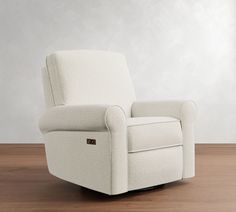 a white recliner sitting on top of a hard wood floor next to a wall