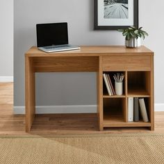 a laptop computer sitting on top of a wooden desk next to a book shelf with books