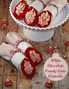 white chocolate candy canes in a bowl on a wooden table with red candies