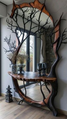 a large mirror sitting on top of a wooden table next to a tree branch design