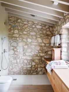 a bathroom with stone walls and wooden floors