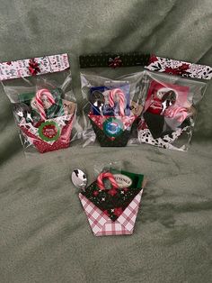 three bags filled with candy canes and candies on top of a green blanket