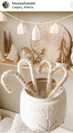 a white vase filled with candy canes on top of a table