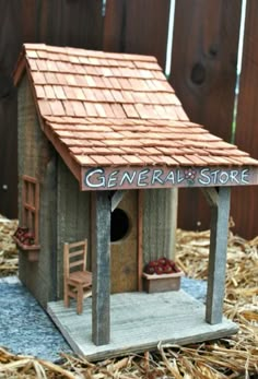 a small wooden birdhouse with the word general store painted on it's roof