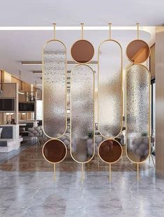 a room divider made out of metal and glass with round mirrors hanging from it