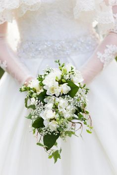 a bridal holding a bouquet of white flowers