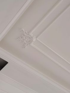 the ceiling is painted white and has an ornate design on it's trimming