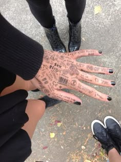 two people with their hands covered in tattoos and writing on the palm of their hands