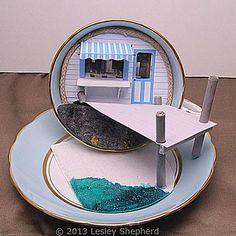 a paper model of a house on a plate with blue and white paint in the center