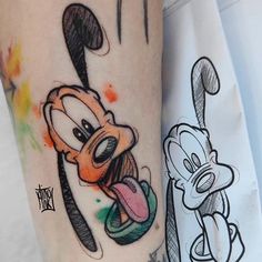 a cartoon character is on the leg of a person with an inked arm and foot