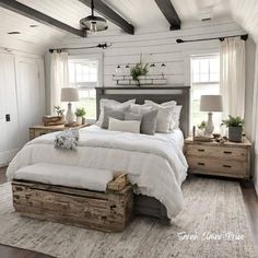 a bedroom with white bedding and wooden furniture in the corner, along with two windows