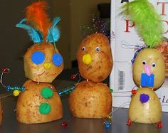 three potatoes with faces made to look like people wearing hats and feathers on their heads