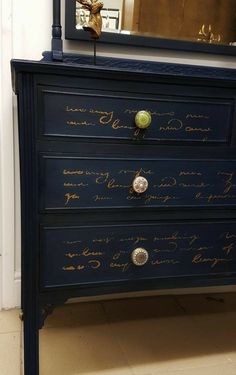 a blue dresser with writing on the drawers