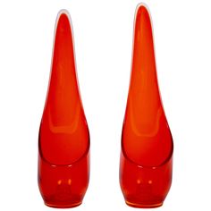 two red vases sitting next to each other on a white surface