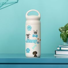 a water bottle sitting on top of a blue table next to a potted plant