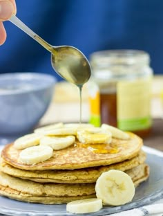 pancakes with banana slices and syrup being drizzled on top