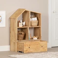 a wooden shelf with baskets on top of it next to a white rug and door