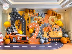 an orange car is parked in front of a backdrop for a race themed birthday party