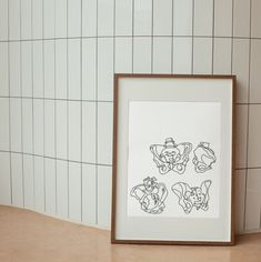 an art print is displayed in front of a tiled wall