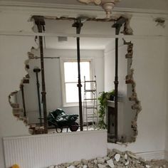 a mirror that is in the middle of a room with broken walls and debris around it