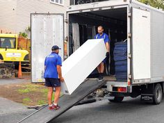 two men unloading boxes from the back of a truck