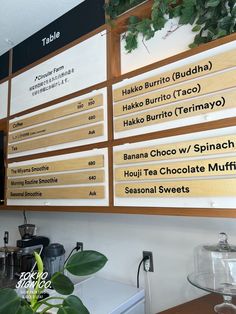 there are many signs on the wall above the counter in this coffee shop that says, hako burrito buddha hako burrito taco waka burrito termayoo spinach