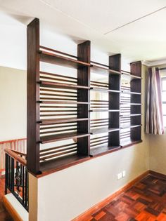 an empty room with wooden flooring and shelving