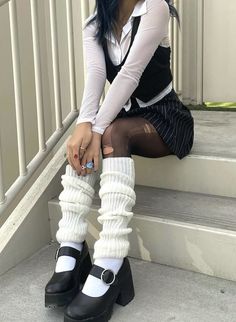 a young woman sitting on the steps with her legs crossed and wearing knee high socks