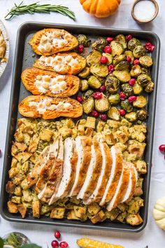 a pan filled with turkey, brussel sprouts and cranberries