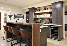 a kitchen with bar stools and brick wall