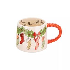 a ceramic mug with christmas stockings and stockings on the inside, has an orange rubber band around it