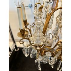 a chandelier hanging from the ceiling with two lights on it and some glass beads