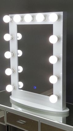 a vanity mirror with lights on top of it