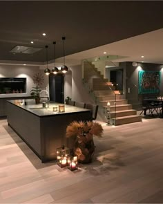 an image of a living room with candles on the floor and stairs in the background