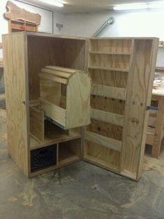 an unfinished wooden cabinet in a garage with shelves and drawers on each side, open to show the contents inside