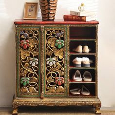 an ornately decorated cabinet with shoes on top