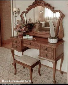 a dressing table with mirror, stool and flower arrangement on the top shelf in front of it