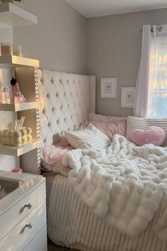 a white bed sitting in a bedroom next to a window