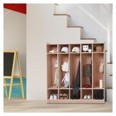 a wooden shelf filled with shoes next to a stair case