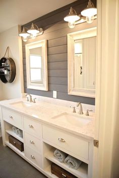 a bathroom with double sinks and two mirrors